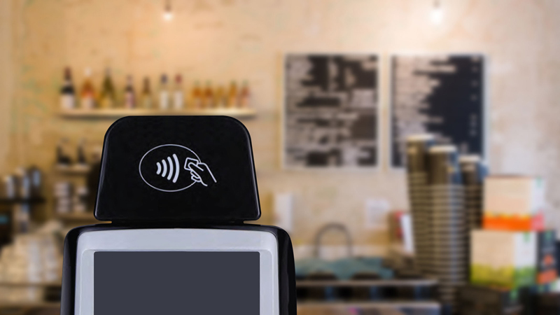 samsungpay_cafe_phone_mszeto_800x450 Closeup of a POS system in a coffee shop displaying the Tap to Pay logo.