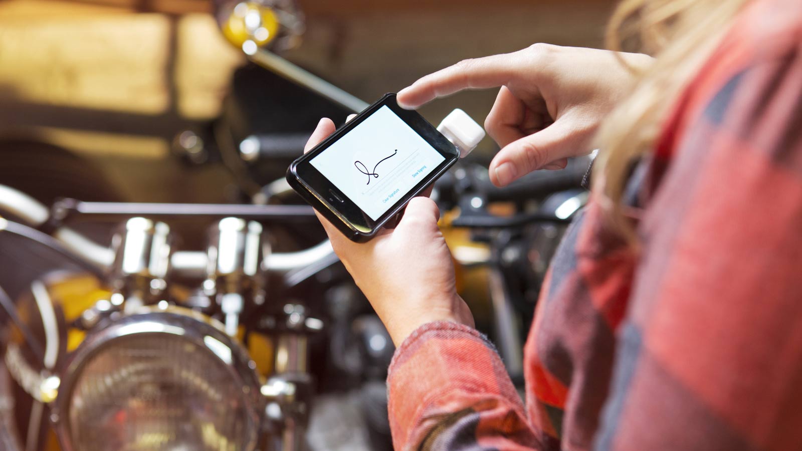 Woman signing for purchase on smart phone.